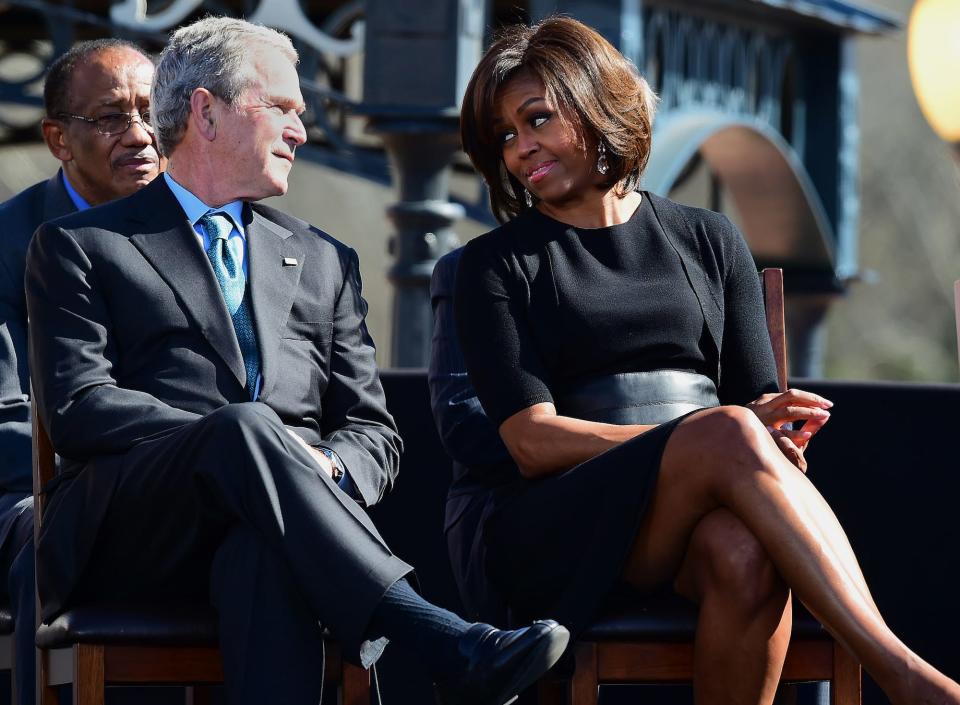 Former President George W. Bush and first lady Michelle Obama speak before President Barack Obama delivers a speech and takes a symbolic walk across the Edmund Pettus Bridge, Saturday, March 7, 2015, in Selma, Alabama.