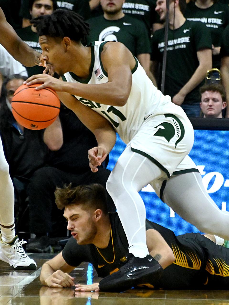 Michigan State Spartans guard A.J. Hoggard (11) takes the ball from Iowa Hawkeyes forward Owen Freeman (32) during the first half at Breslin Center in East Lansing on Tuesday, Feb. 20, 2024.