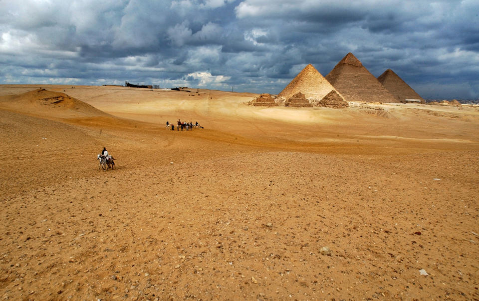 <p>Tourists ride rented horses and camels at the historical site of the Giza Pyramids, near Cairo, Egypt, a day before the Muslim Eid al-Adha or the Feast of Sacrifice, Jan. 19, 2005. (Photo: Muhammed Muheisen/AP) </p>