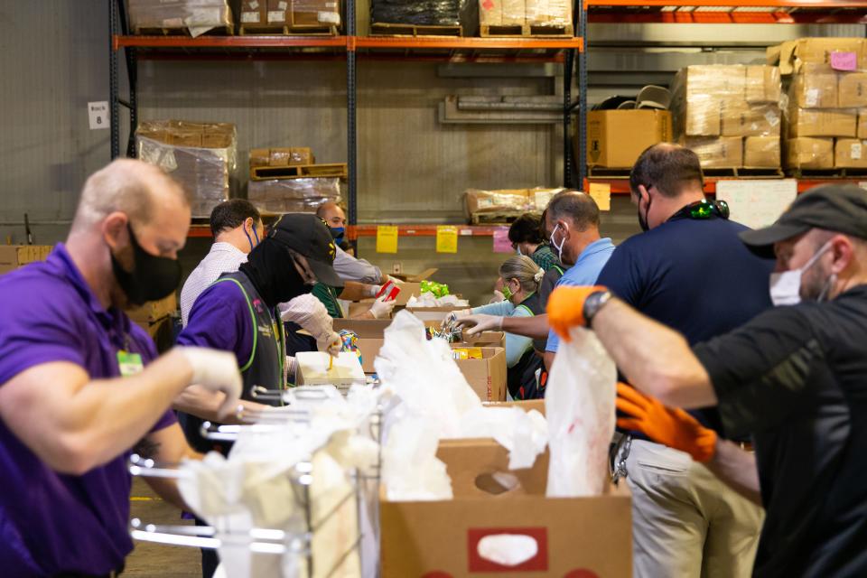 Volunteers from Tyson, Bimbo Bakery and Walmart sort donated food at a Feeding Northeast Florida warehouse.