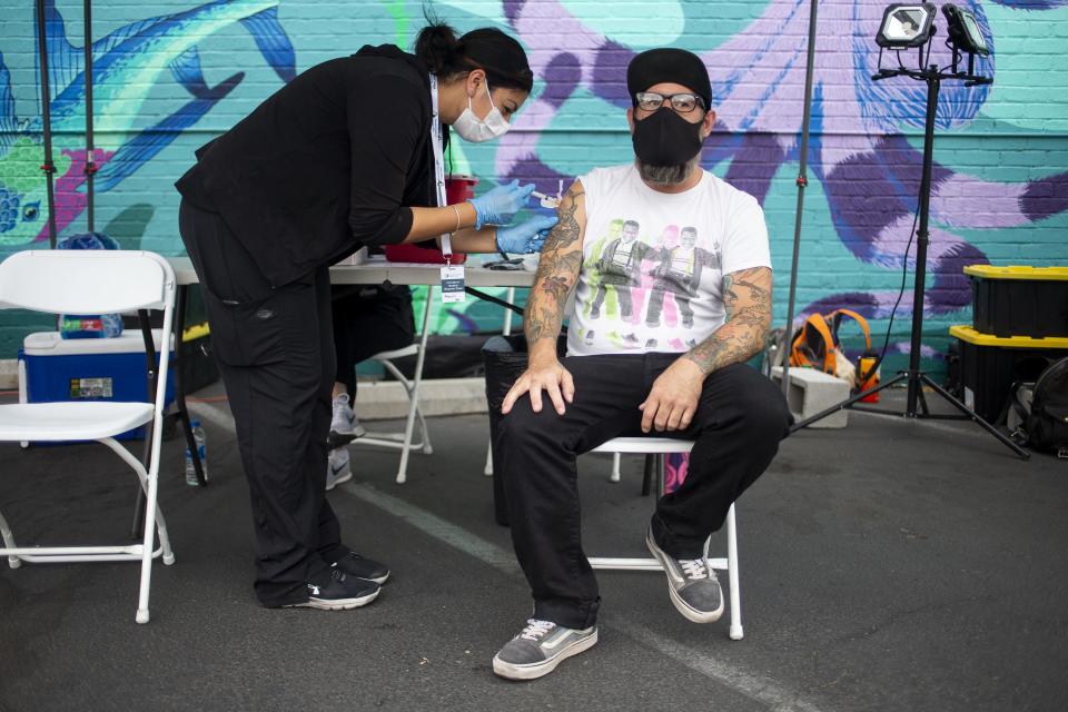 Justin McCawley receives a COVID-19 vaccine at a pop-up site in the parking lot next to Antigone Books in Tucson, Ariz., on May 20, 2021.