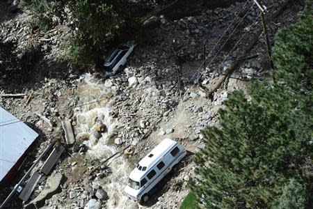 A rescue helicopter flies over vehicles in Lyons, Colorado which was hard hit by flood waters September 17, 2013. REUTERS/Mark Leffingwell