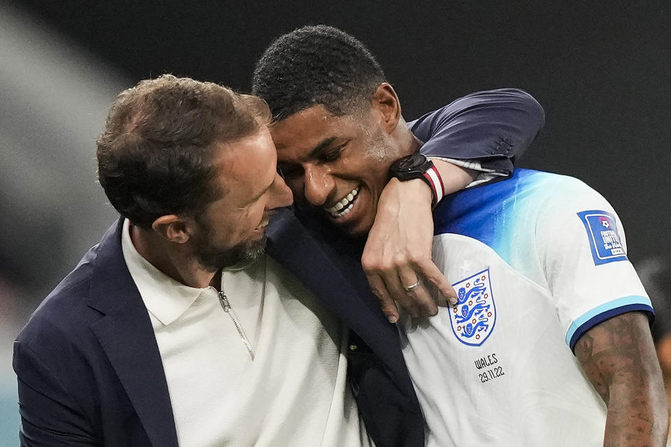 Marcus Rashford (derecha) es felicitado por el técnico de Inglaterra Gareth Southgate tras la victoria 3-0 ante Gales en el partido por el Grupo B del Mundial, el martes 29 de noviembre de 2022, en Rayán, Qatar. (AP Foto/Frank Augstein)