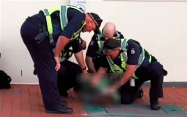 The clip shows a child, believed to be 12, doubled over on the ground as four male officers restrain him. Picture: 3AW