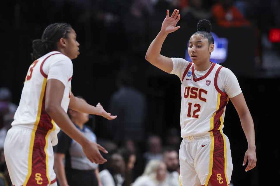 Southern California center Rayah Marshall, left, and guard JuJu Watkins (12) greet each other on the court during the first half of a Sweet 16 college basketball game against Baylor in the women's NCAA Tournament, Saturday, March 30, 2024, in Portland, Ore. (AP Photo/Howard Lao)