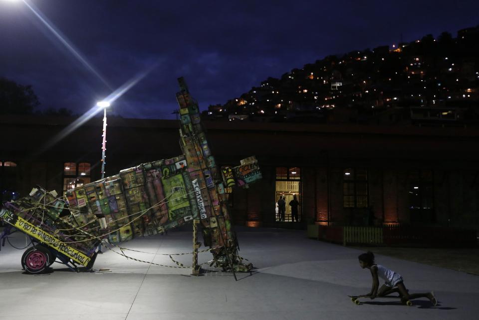 A girl plays with a skateboard next to a work by Mundano during the Art Rua street art festival in Rio de Janeiro September 6, 2013. The Art Rua festival, taking place over four days, involves exhibitions by more than 40 foreign and Brazilian artists, galleries and art crews, as well as parties, shows and lectures celebrating urban art. (REUTERS/Ricardo Moraes)