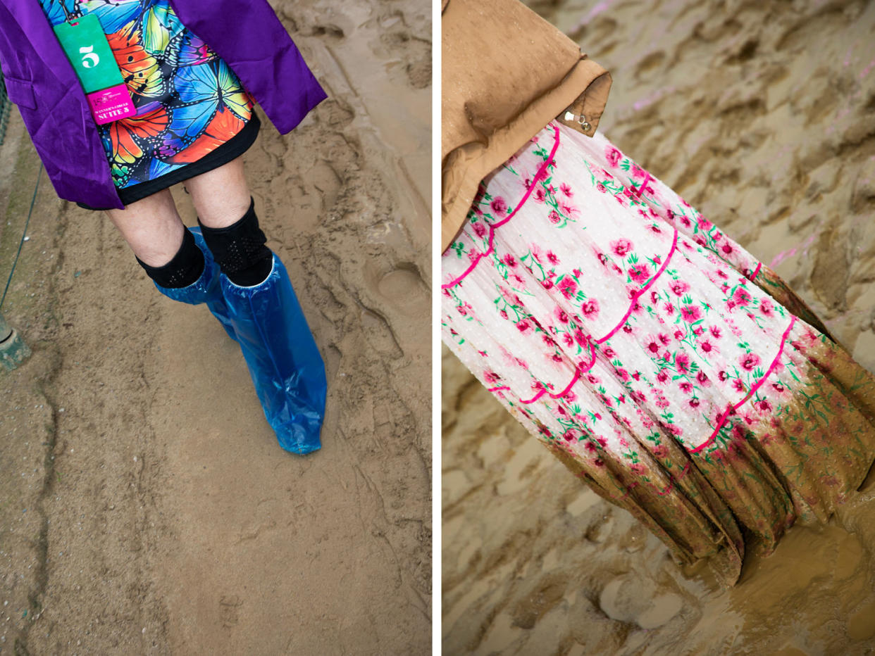 A woman walks through the mud in plastic-covered boots; a woman's floral skirt is caked in mud.