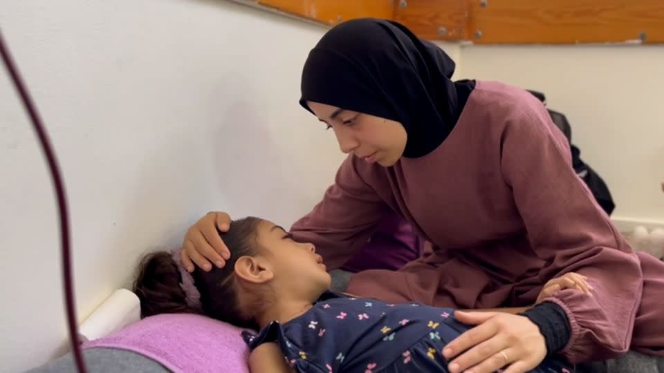 Umm Ubaida comforts her daughter, Yasmin, aged 5, in Nasser Hospital, on Tuesday. - CNN