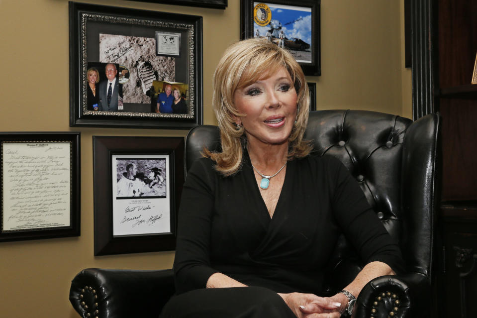 FILE - In this Tuesday, April 18, 2017 file photo, Carol Mersch talks during an interview in her home in Tulsa, Okla. Behind her are some of the photographs and space program memorabilia she has collected. Months after the Museum of the Bible was forced to admit some of its collection of Dead Sea Scrolls are apparent forgeries, the institution has replaced a space-age exhibit whose authenticity was questioned. The postage stamp-sized Bible now on display was donated by Mersch, who initially questioned the first Bible's authenticity. (AP Photo/Sue Ogrocki, File)