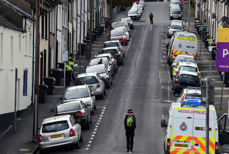 Police officers stand at either end of a street as officers search a house after three men were arrested in connection with an explosion on the London Underground, in Newport, Wales, Britain, September 20, 2017. REUTERS/Rebecca Naden