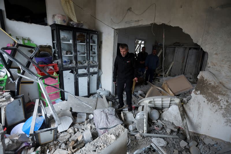 Qazim Jaber, mayor of the village of Mhaibib, inspects the damage inside a house in the village