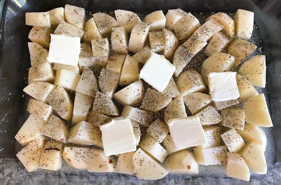 Adding butter to Dad's Greek Lemon Potatoes