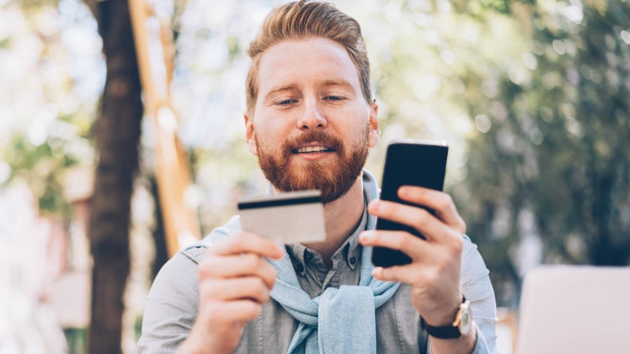 Young businessman shopping online using credit card, smartphone and lap top.