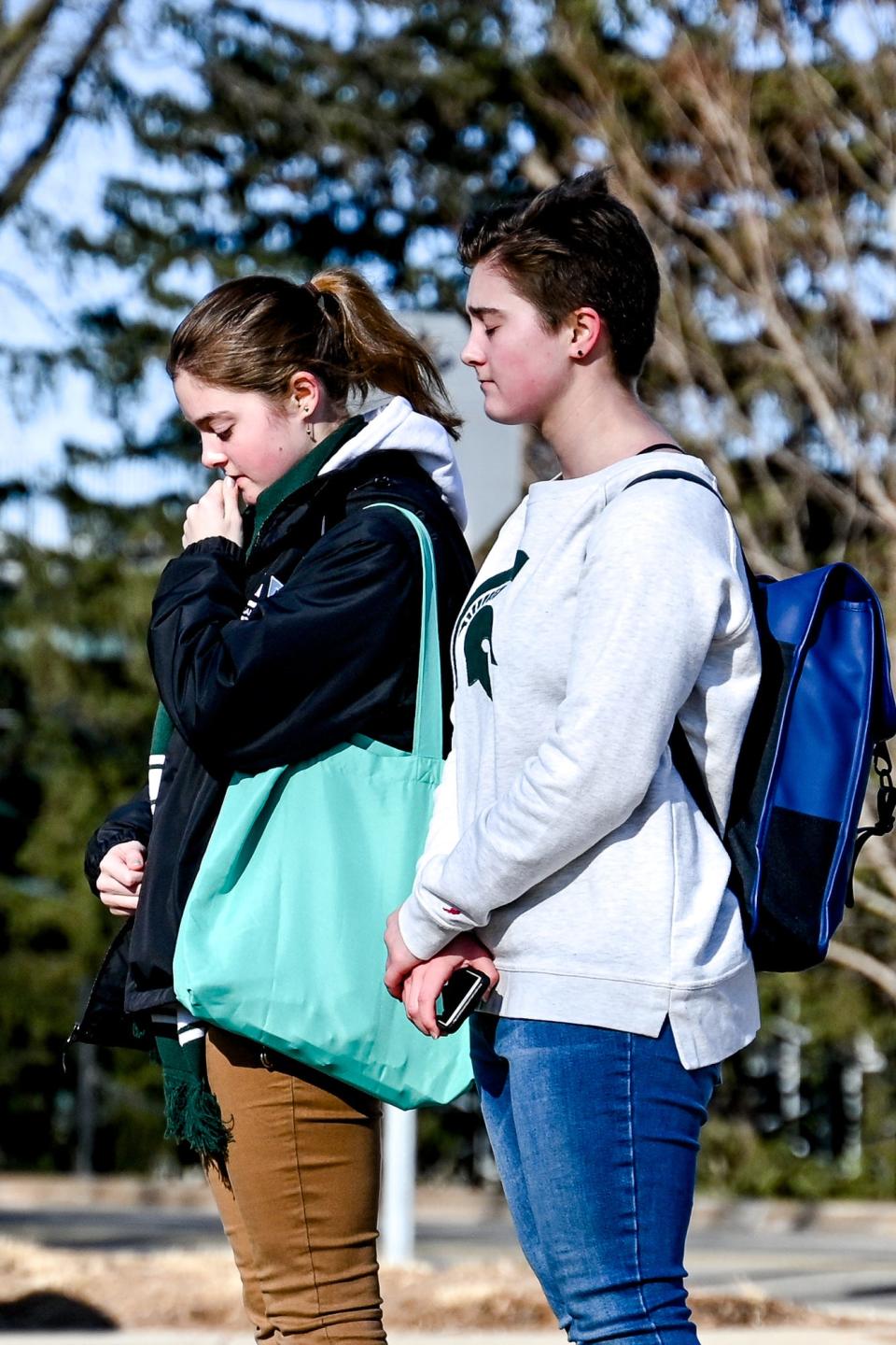 Michigan State sophomore Emma Nicolaysen, left, and her sister, junior Maren, pause to reflect at the Sparty statue on Tuesday, Feb. 14, 2023, on the MSU campus in East Lansing.