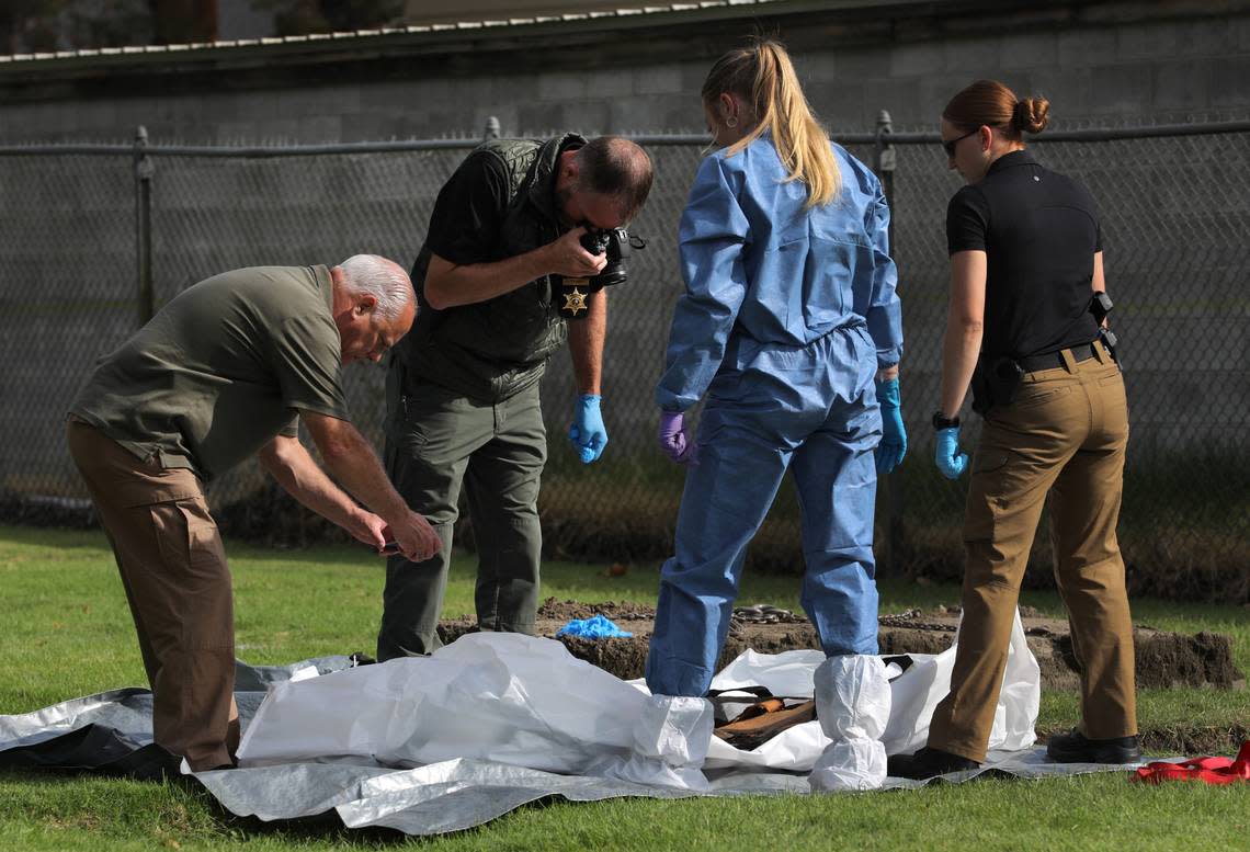 Officials from the Benton County Coroner’s Office and the Benton County Sheriff’s Office document the exhumation of an unidentified woman’s remains from 1986.