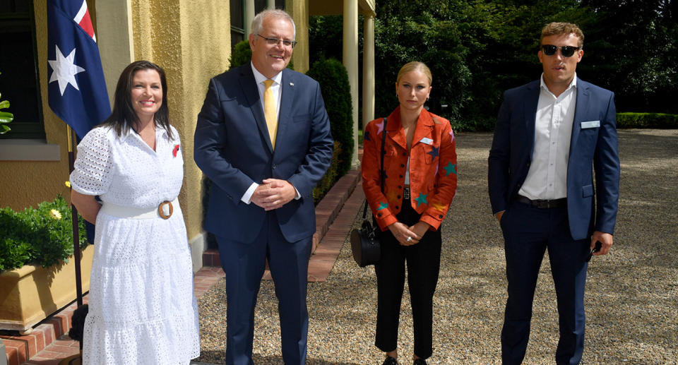 Scott Morrison and wife Jenny smiling at camera standing next to Grace Tame and fiance Max Heerey who are not smiling. 