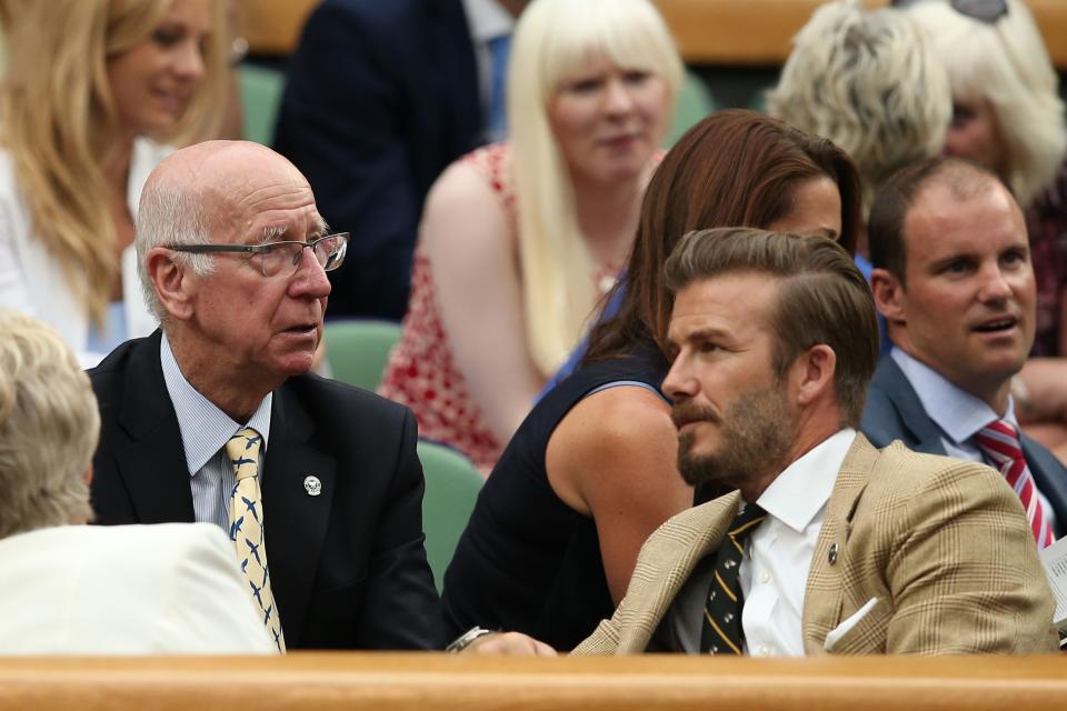 Former English footballer David Beckham (R) talks with Former England footballer Bobby Charlton (L) in the royal box on centre court as Spain's Rafael Nadal plays against Kazakhstan's Mikhail Kukushkin during their men's singles third round match on day six of the 2014 Wimbledon Championships at The All England Tennis Club in Wimbledon, southwest London, on June 28, 2014. AFP PHOTO / ANDREW YATES  - RESTRICTED TO EDITORIAL USE (Photo by Andrew YATES / AFP)        (Photo credit should read ANDREW YATES/AFP via Getty Images)