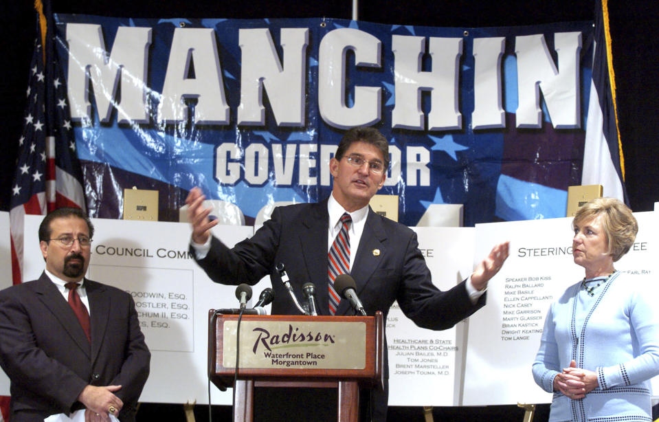 FILE - Joe Manchin, center, along with his wife, Gayle Manchin, right, and Transition Chairman Larry Puccio are shown at a news conference Wednesday, Nov. 3, 2004, in Morgantown, W.Va., a day after he was elected governor. Now at the end of his second term as a U.S. senator, Manchin is still not a declared candidate for any office five months before the 2024 general election. But there’s still time to mull potential runs for governor, the Senate, and even the U.S. presidency. (AP Photo/Dale Sparks, File)