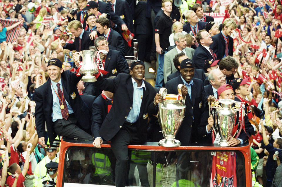 Manchester United celebrate winning the treble as the jubilant team make their way through Manchester during an open top bus parade. Teddy Sheringham, Dwight Yorke, Andy Cole, Phil Neville, David Beckham among the team members on the bus. 27th May 1999. (Photo by Morris & Stenning/Mirrorpix/Getty Images)