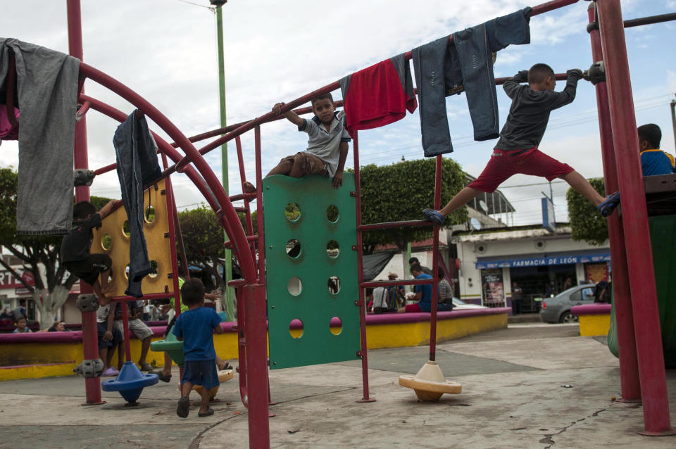 Migrant children play at the central park in Ciudad Hidalgo, Mexico, Saturday, Oct. 20, 2018. About 2,000 Central American migrants who circumvented Mexican police at a border bridge and swam, forded and floated across the river from Guatemala decided on Saturday to re-form their mass caravan and continue their trek northward toward the United States. (AP Photo/Oliver de Ros)