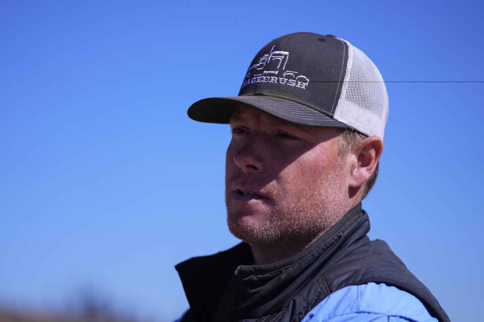 Chance Bowers looks on as his dead cattle is collected after he lost more than 200 head of cattle in the Smokehouse Creek Fire, Friday, March 1, 2024, in Skellytown, Texas. The wildfire, which started Monday, has left behind a charred landscape of scorched prairie, dead cattle and burned-out homes in the Texas Panhandle. (AP Photo/Julio Cortez)