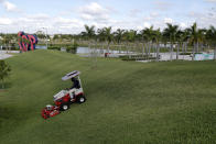 A worker mows the berm outside the Washington Nationals spring training baseball facility, Monday, March 16, 2020, in West Palm Beach, Fla. (AP Photo/Julio Cortez)