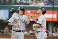 Seattle Mariners Evan White, left, is congratulated by Kyle Seager, right, after scoring a run against the Texas Rangers during the fifth inning of a baseball game Sunday, May 9, 2021, in Arlington, Texas. (AP Photo/Michael Ainsworth)
