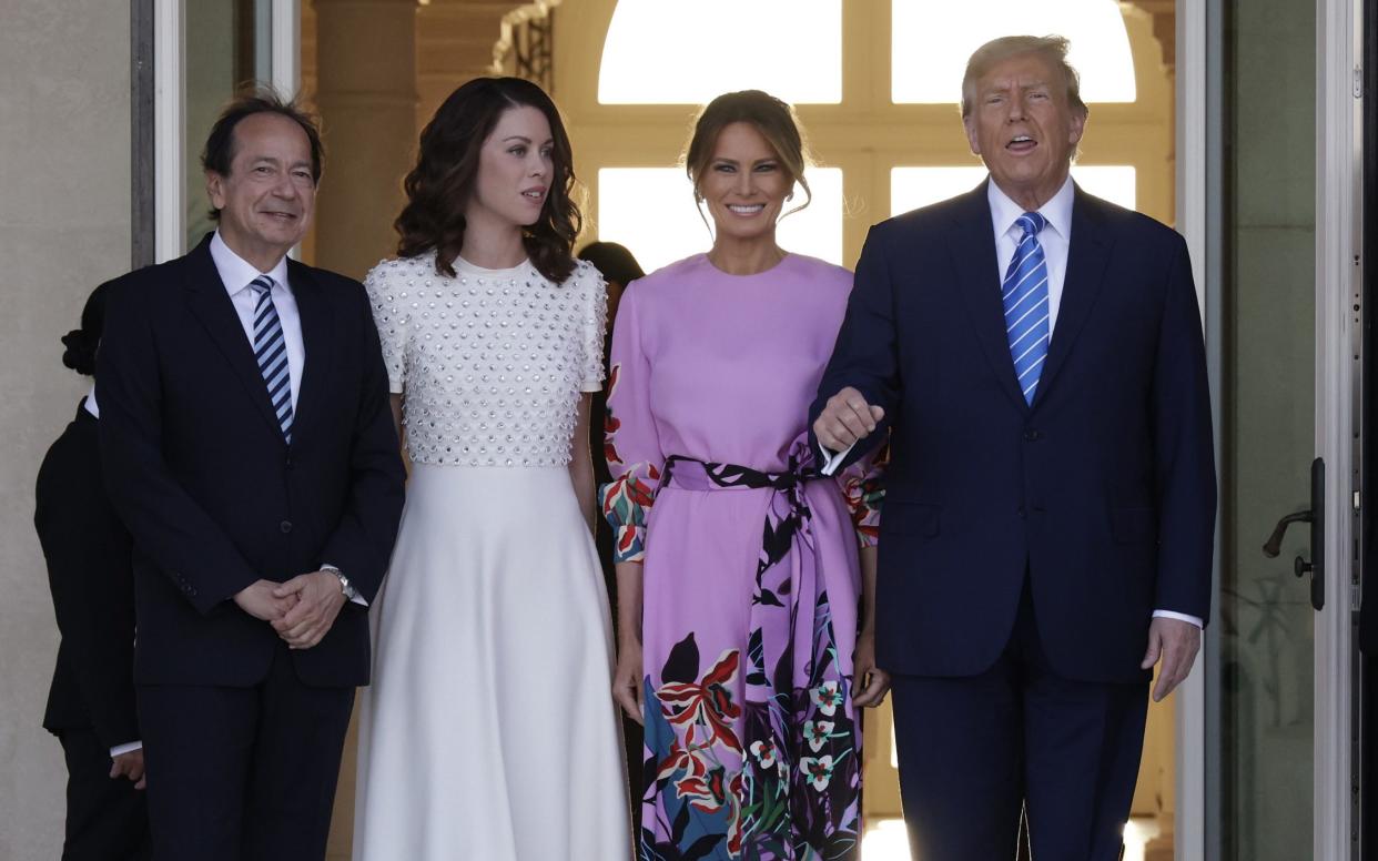 Mr Trump arriving at the fundraising event with his wife Melania