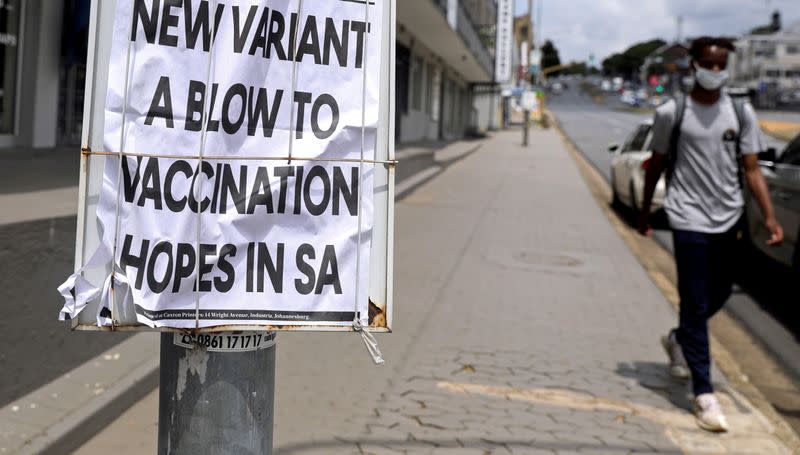 FILE PHOTO: A man walks past newspaper billboards during the coronavirus disease (COVID-19) outbreak in Johannesburg