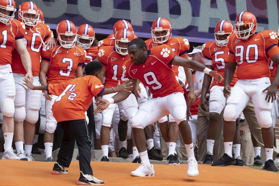 Ray McElrathbey (Jay Reeves, center right) and his little brother Fahmarr (Thaddeus J. Mixson) get hyped before a Clemson game in the Disney+ sports drama "Safety."