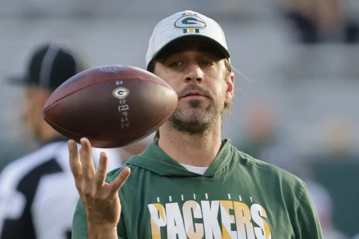 Aaron Rodgers holds a football during warmups before a 2021 preseason game.