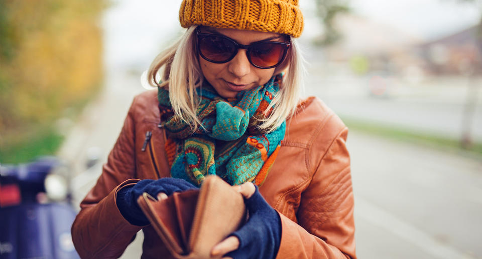 A woman looking through her wallet. NSW drivers will be able to ditch their plastic licences if they want to from August.