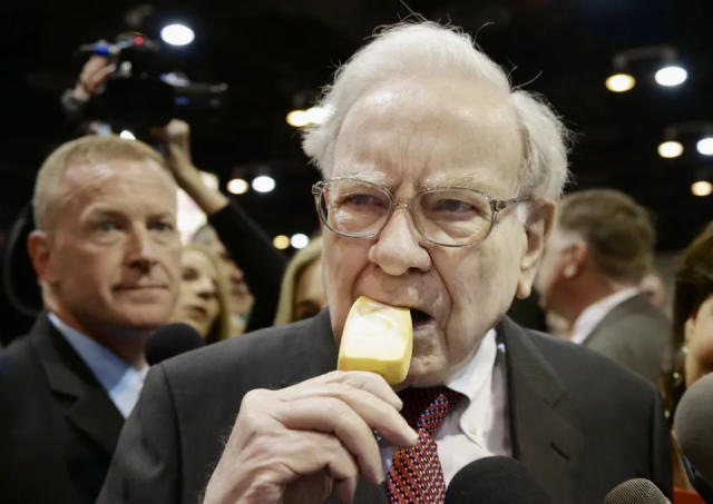 El presidente y director ejecutivo de Berkshire Hathaway, Warren Buffett, comi&#xe9;ndose un helado mientras recorre el sal&#xf3;n de exhibici&#xf3;n antes de la reuni&#xf3;n anual de accionistas el s&#xe1;bado 3 de mayo de 2014 en Omaha, Nebraska (Foto AP/Nati Harnik)
