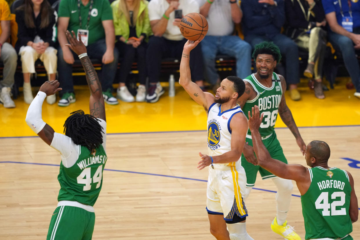 Golden State Warriors superstar Stephen Curry gets his shot off between Boston Celtics big men Robert Williams III and Al Horford. (Darren Yamashita/USA Today Sports)