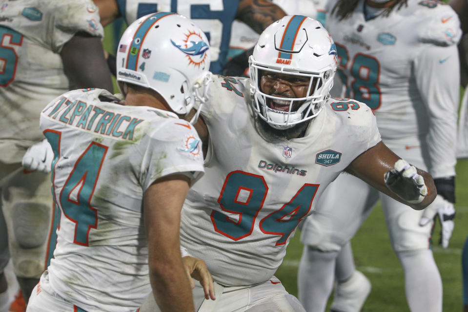 Miami Dolphins tackle Christian Wilkins (94) celebrates with quarterback Ryan Fitzpatrick (14) after Fitzpatrick scored a touchdown on a 1-yard run against the Jacksonville Jaguars during the second half of an NFL football game, Thursday, Sept. 24, 2020, in Jacksonville, Fla. (AP Photo/Stephen B. Morton)
