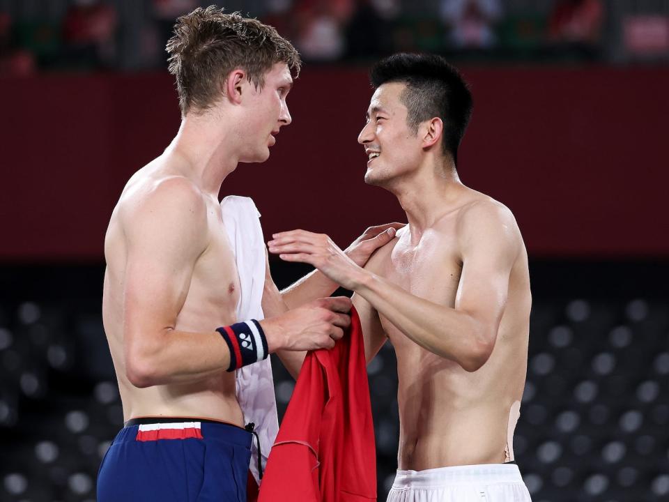 Viktor Axelsen of Team Denmark and Chen Long of Team China swap jerseys in badminton.