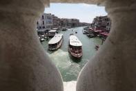 Public transport boats carrying tourists and citizens navigate along the Grand Canal, in Venice, Italy, Thursday, June 17, 2021. After a 15-month pause in mass international travel, Venetians are contemplating how to welcome visitors back to the picture-postcard canals and Byzantine backdrops without suffering the indignities of crowds clogging its narrow alleyways, day-trippers perched on stoops to imbibe a panino and hordes of selfie-takers straining for a spot on the Rialto Bridge or in front of St. Mark’s Basilica. (AP Photo/Luca Bruno)