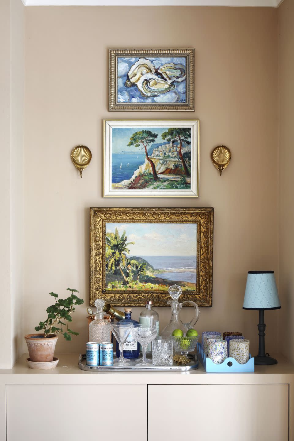 a tray loaded with glassware, spirits and decanters for a playful bar area in an alcove