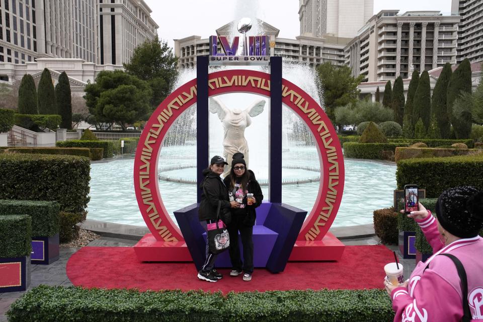 People pose for photos at Caesars Palace along the Las Vegas Strip ahead of the Super Bowl, Thursday, Feb. 1, 2024, in Las Vegas. Las Vegas is scheduled to host the Super Bowl 58 on Sunday, Feb. 11, 2024. (AP Photo/John Locher)