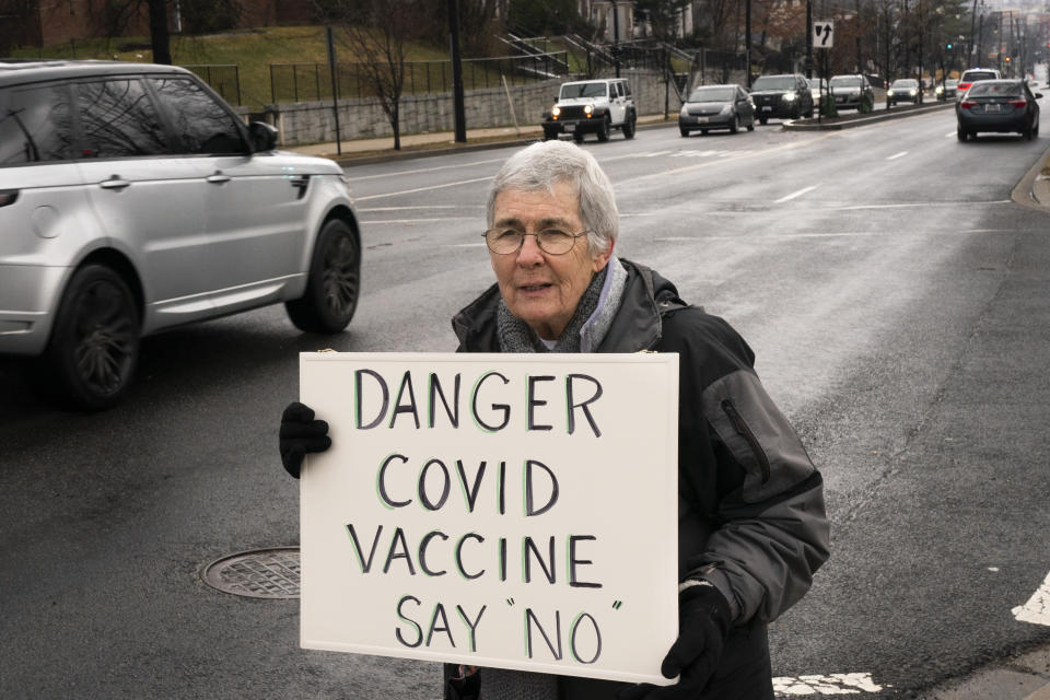 In this Thursday, Feb. 11, 2021, photo Kathy Boylan, 77, of Washington, who says she has never received any vaccinations herself, protests the COVID-19 vaccine, Thursday, Feb. 11, 2021, outside the Pennsylvania Avenue Baptist Church that was hosting a vaccination clinic in southeast Washington. (AP Photo/Jacquelyn Martin)