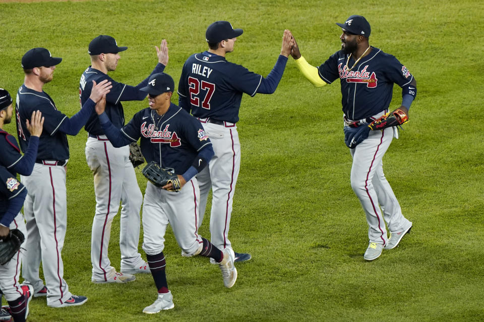 Atlanta Braves third baseman Austin Riley (27), left fielder Marcell Ozuna, right, and teammates celebrate after a baseball game against the New York Yankees, Wednesday, April 21, 2021, at Yankee Stadium in New York. The Braves won 4-1. (AP Photo/Kathy Willens)