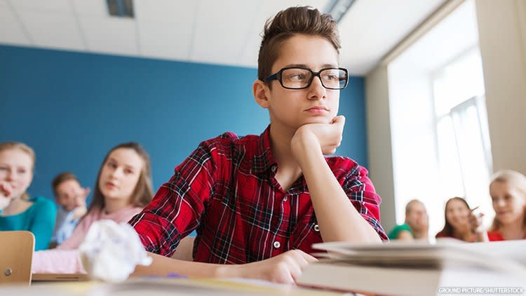 Boy in classroom looking upset