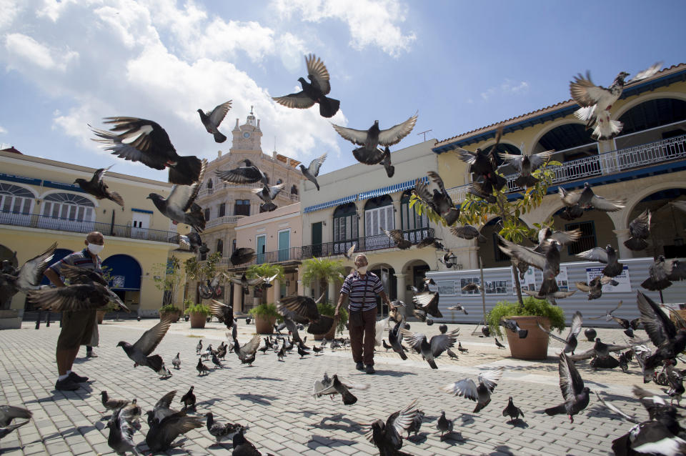 Las palomas alzan el vuelo en la Plaza Vieja vacía en La Habana, Cuba, el martes 23 de junio de 2020. Casi tres meses de un cierre casi total del comercio, el transporte y los espacios públicos, combinado con el monitoreo de la salud y las pruebas de virus han llevado a la virtual eliminación de COVID-19 en Cuba. (AP Foto/Ismael Francisco)