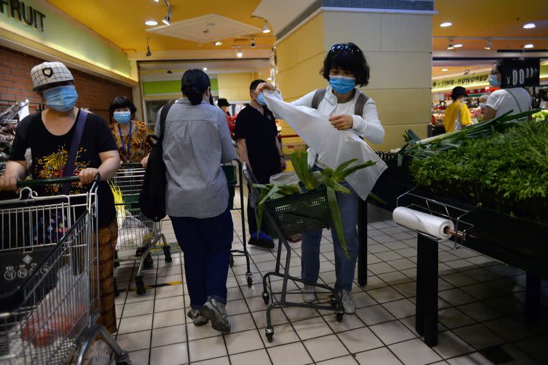 Personas usan mascarillas mientras compran verduras en un supermercado en Pekín, China, el 15 de junio de 2020