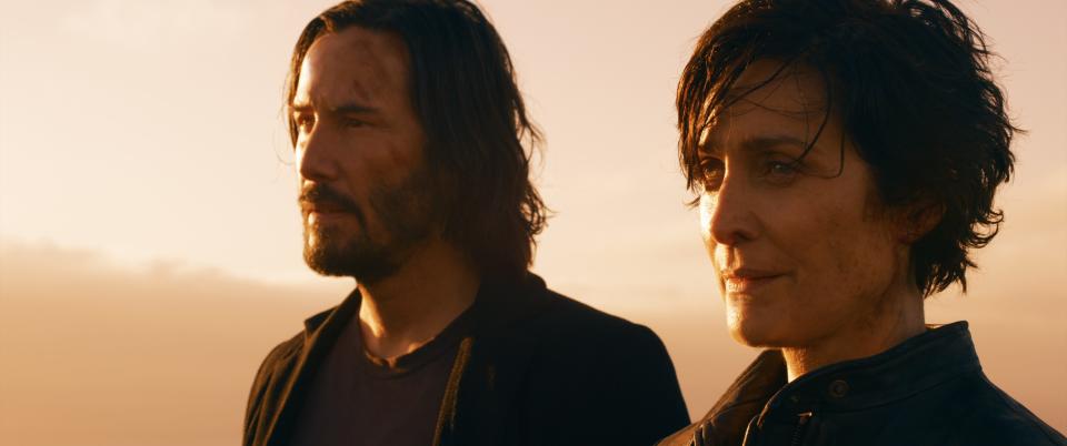 Carrie-Anne Moss and Keanu Reeves on top of the roof at dawn, shooting a scene from "The Matrix Resurrections."