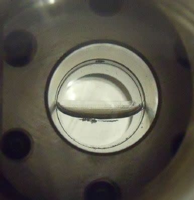 A methane ice sample ready for investigation by Northern Arizona University's ice lab. The methane is visible in the lower half of the cell.