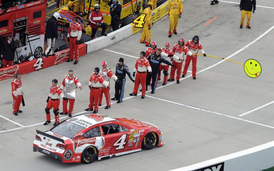 Kevin Harvick (4) pulls off pit road as his crew members wave before the start of a NASCAR Sprint Cup auto race at Martinsville, Speedway, Sunday, March 30, 2014, in Martinsville, Va. (AP Photo/Mike McCarn)