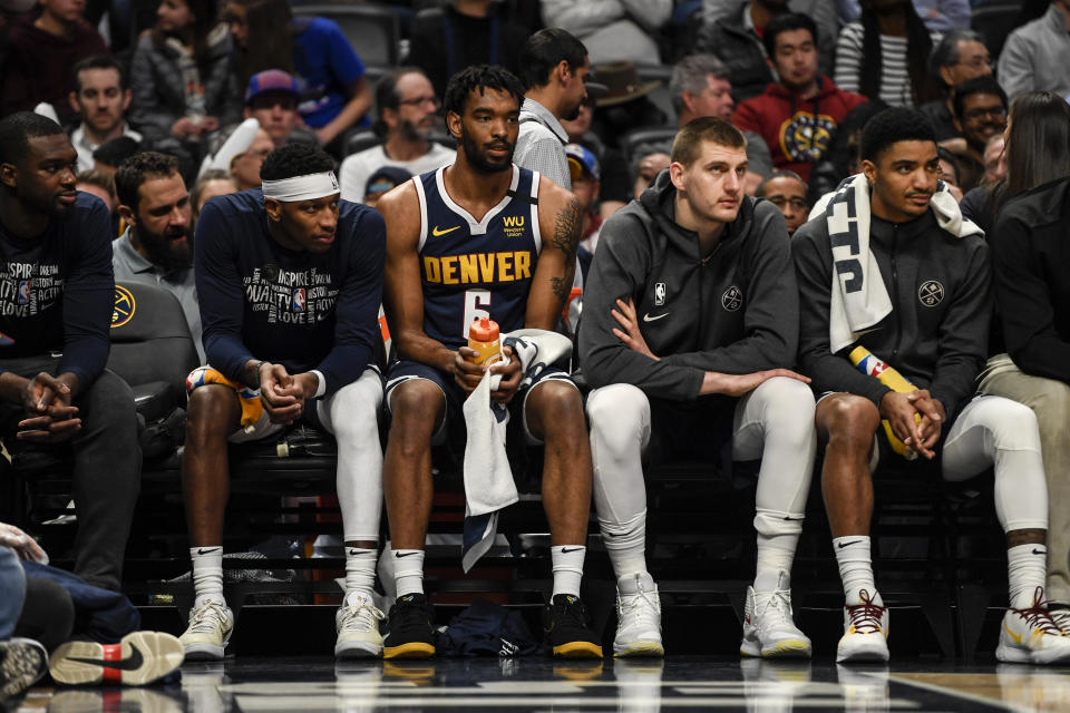 Members of the Denver Nuggets sitting on the bench.