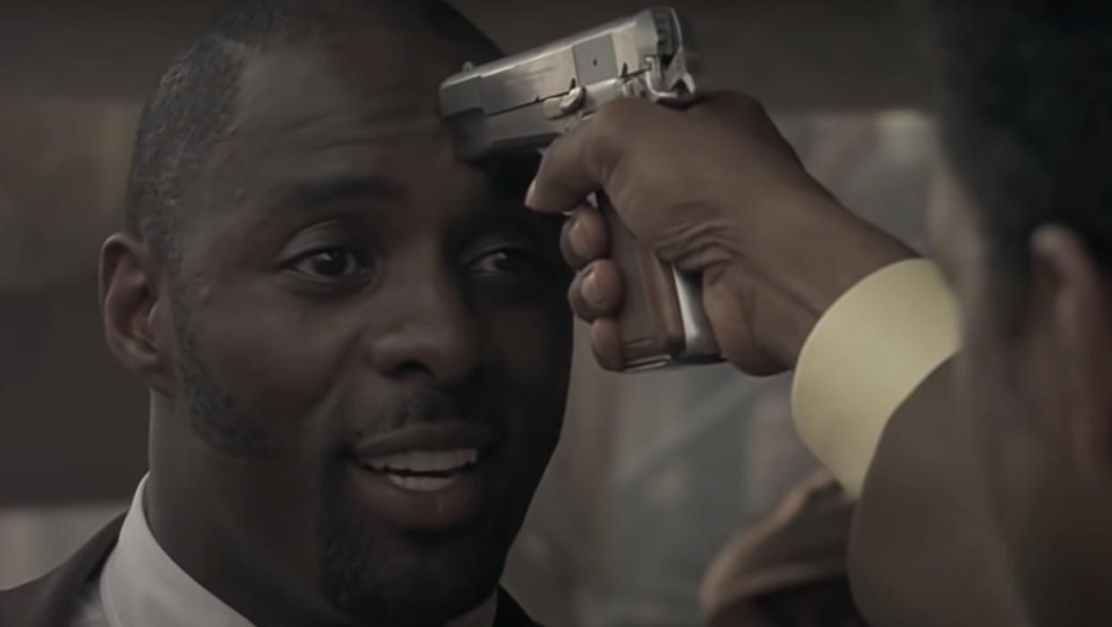 Denzel presses the gun on Idris' head