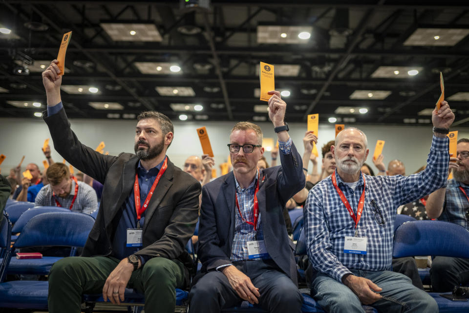 Messengers raise their ballots in support of a motion put up for vote during a Southern Baptist Convention annual meeting Tuesday, June 11, 2024, in Indianapolis. (AP Photo/Doug McSchooler)